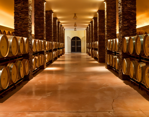 a row of wine barrels are lined up in a wine cellar
