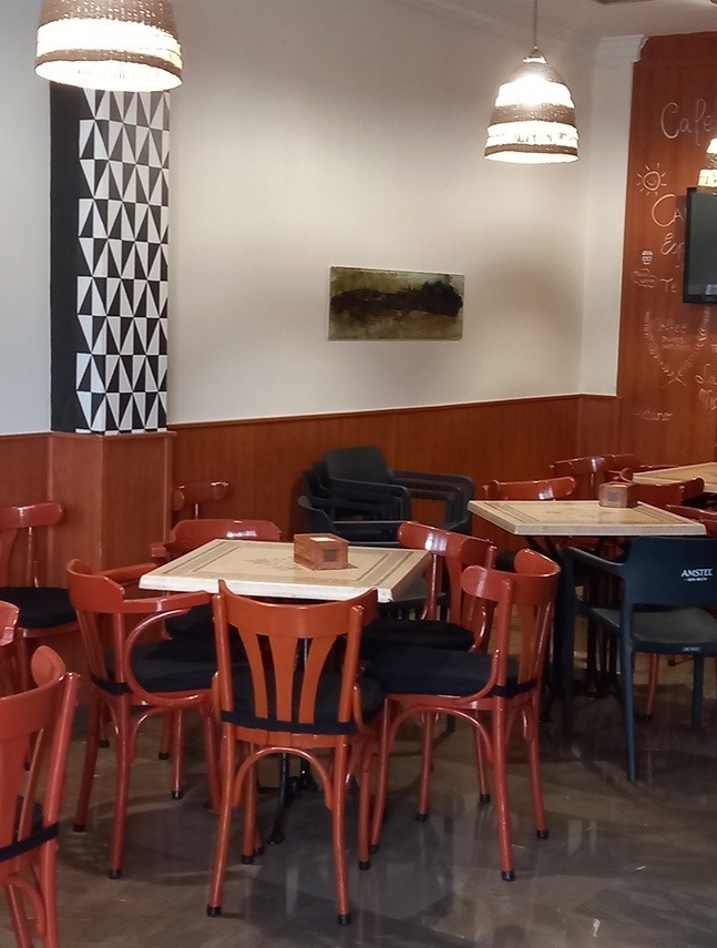 una habitación llena de mesas y sillas con una mesa que dice amstel