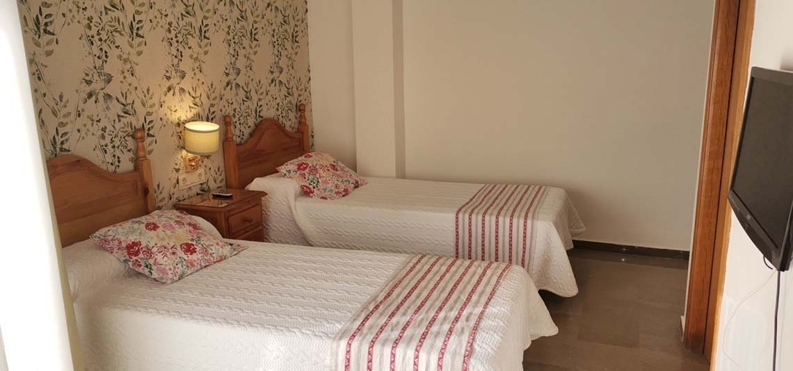 a bedroom with two beds and a flat screen tv