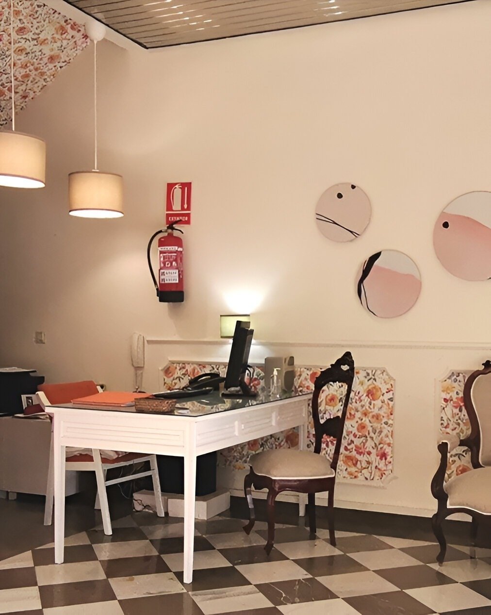 una habitación con una mesa y sillas y un extintor en la pared