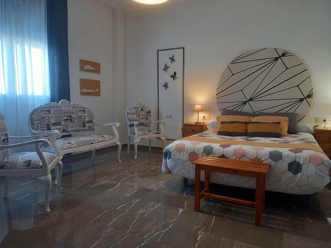 a bedroom with a bed and chairs with newspapers on them