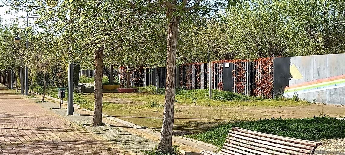 un banco de madera junto a un árbol en un parque