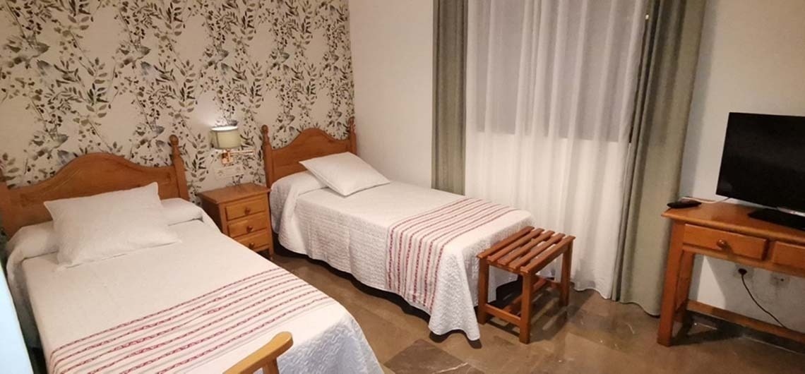 a bedroom with two beds and a flat screen tv