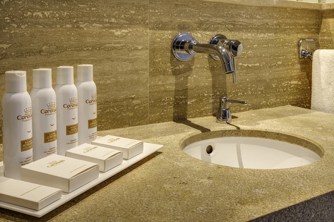 a bathroom with a sink and bottles of carolin