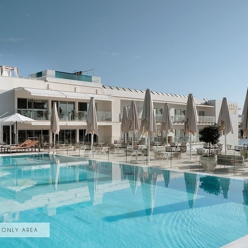 ein großer Swimmingpool vor einem großen weißen Gebäude