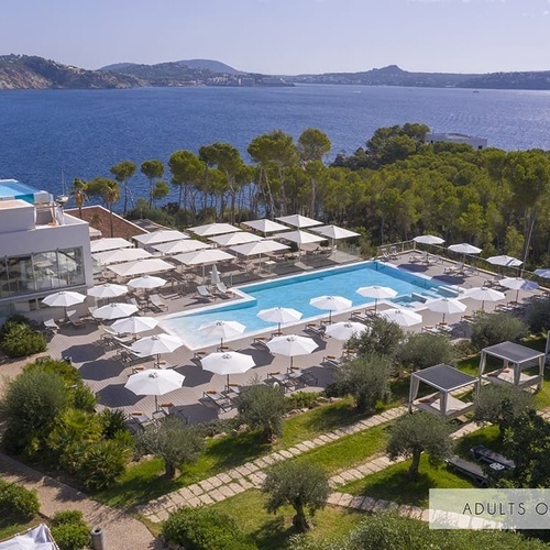 ein Hotel mit einem großen Pool und vielen Sonnenschirmen