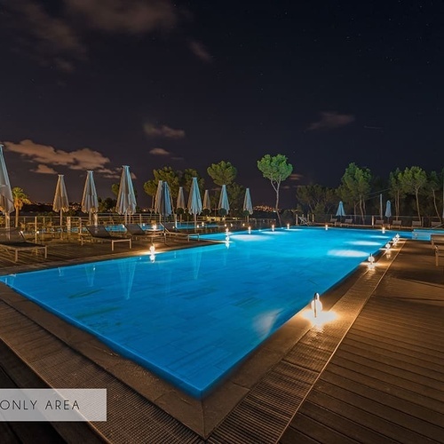 ein großer Swimmingpool mit vielen Sonnenschirmen und Liegestühlen