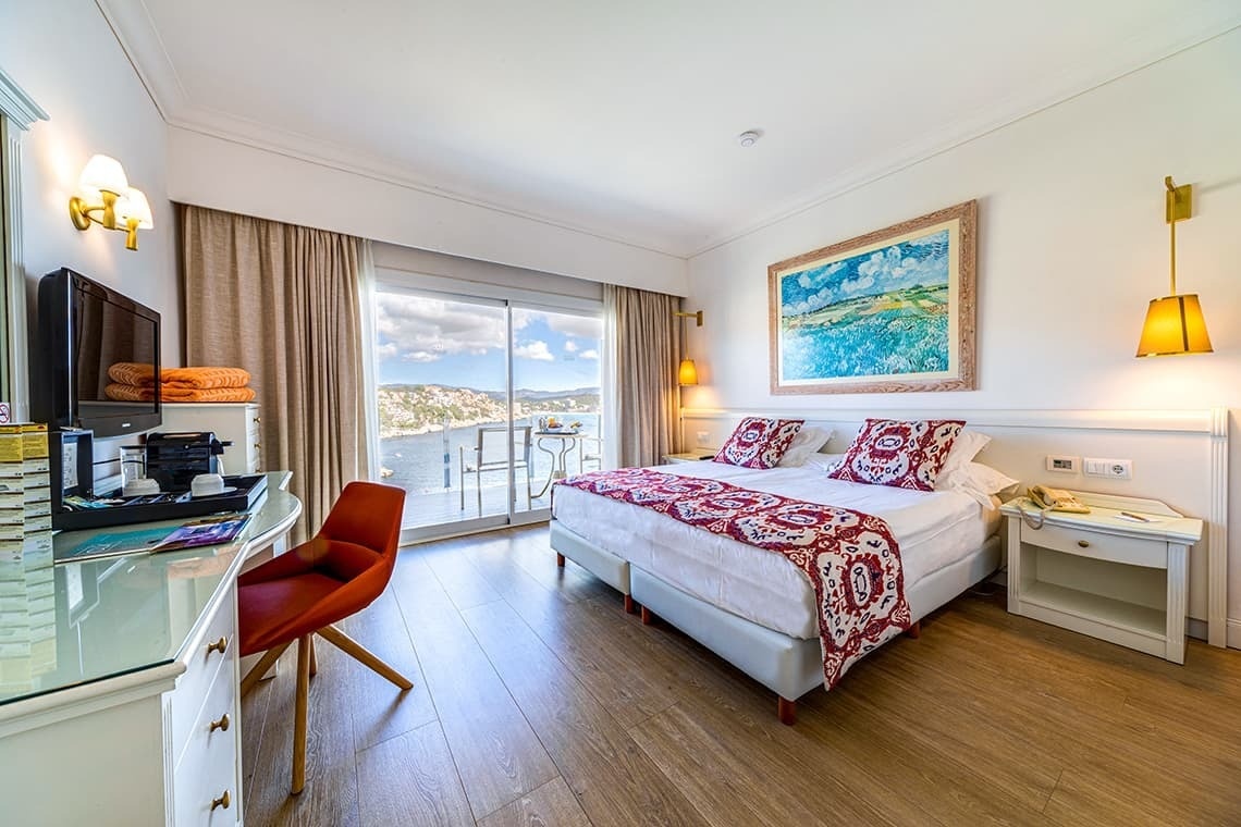 a hotel room with a painting on the wall above the bed