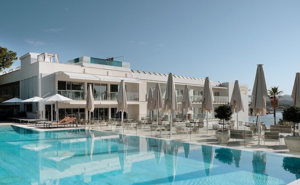 ein Hotel mit einem großen Pool und vielen Sonnenschirmen