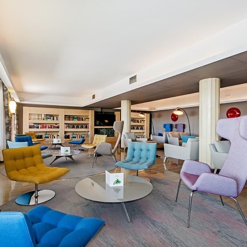 ein Wohnzimmer mit vielen Stühlen und einem Tisch