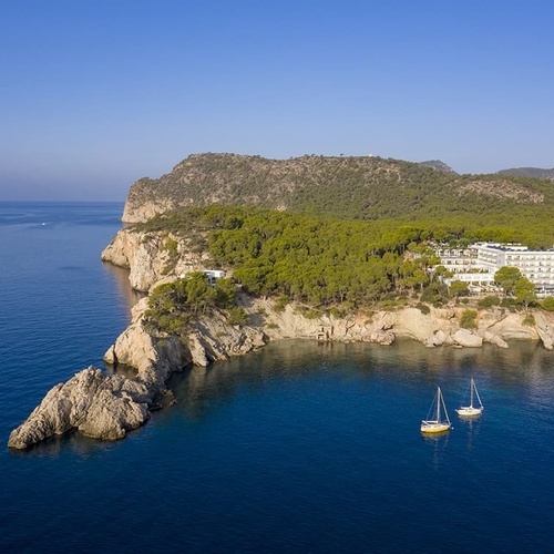 ein großes weißes Gebäude sitzt auf einer Klippe über dem Ozean