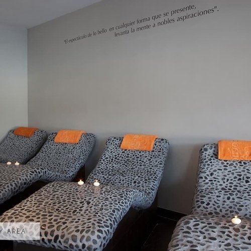 ein Raum mit Liegestühlen und Kerzen und der Aufschrift 