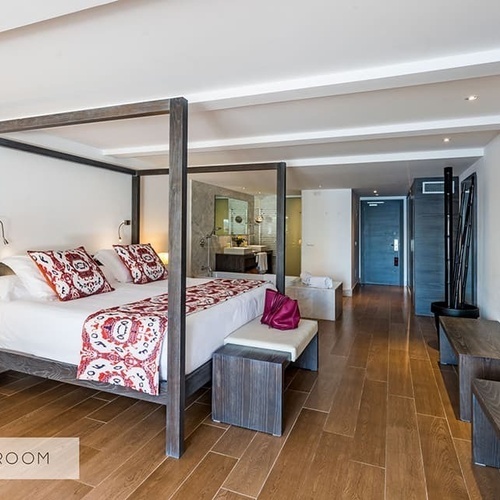 ein Hotelzimmer mit einem Himmelbett und einem Fernseher