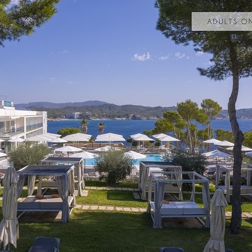 ein großes Hotel mit einem Pool und vielen Sonnenschirmen