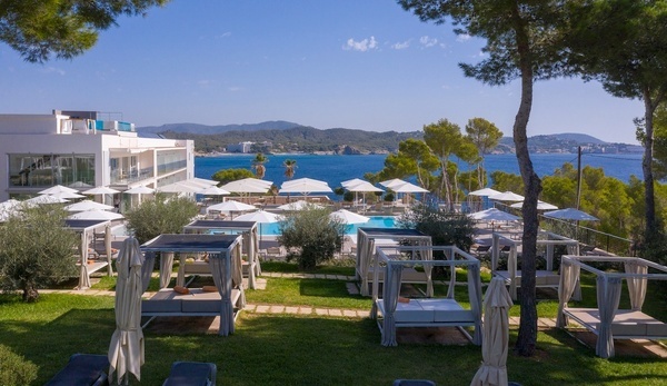 ein Hotel mit einem großen Pool und vielen Sonnenschirmen