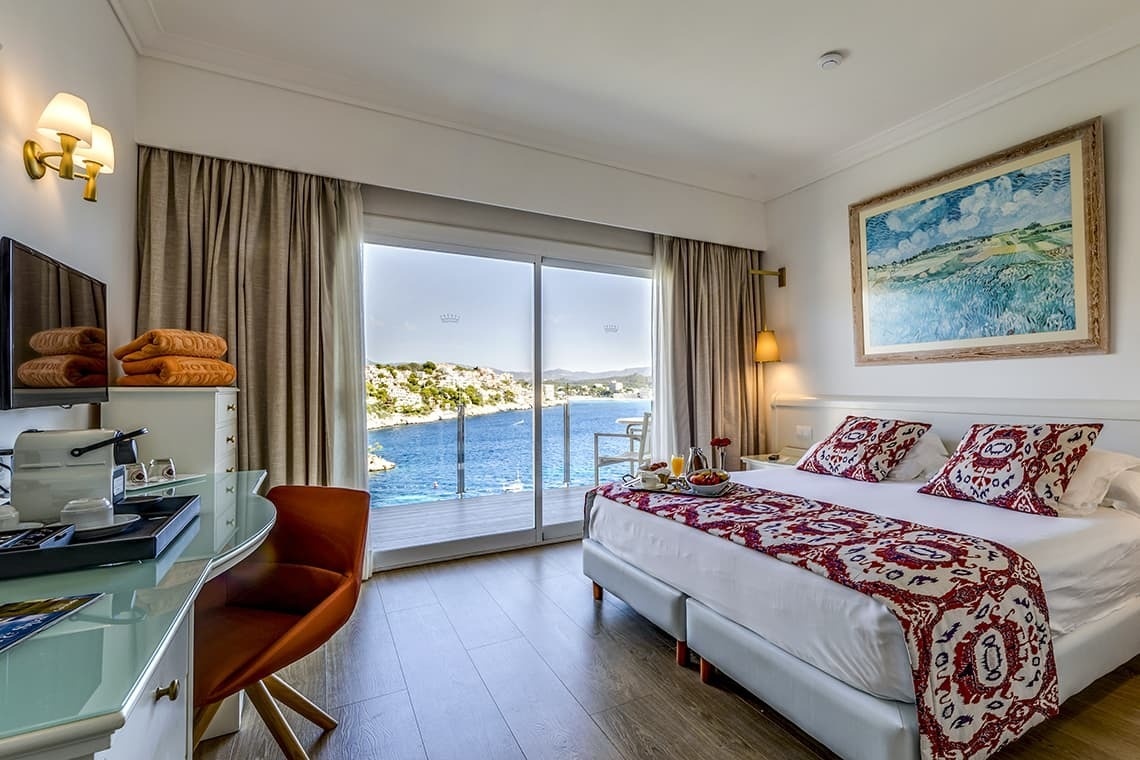 a hotel room with a large bed and a painting on the wall