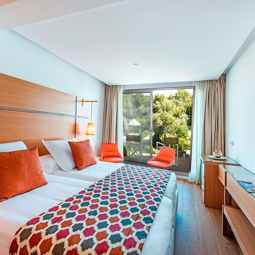 ein Hotelzimmer mit zwei Betten und einem Fernseher