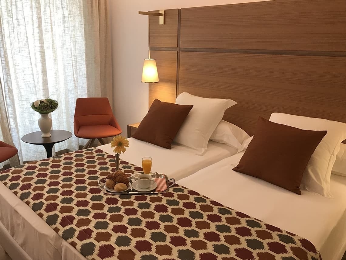 a hotel room with two beds and a tray of food on the bed