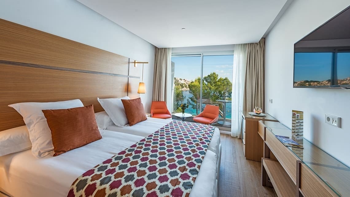 a hotel room with two beds and a flat screen tv