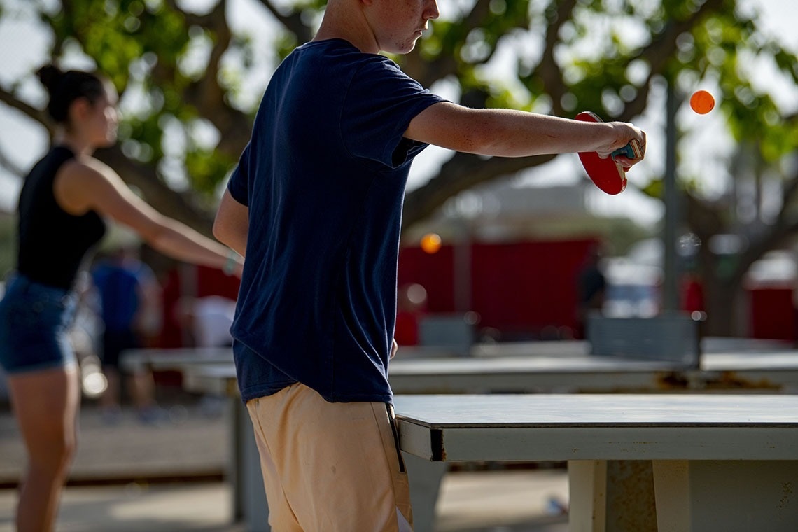 un hombre y una mujer juegan al tenis de mesa
