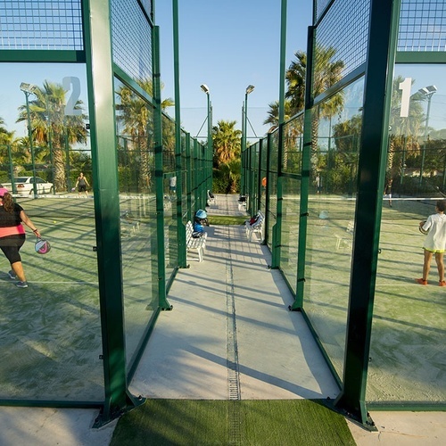 una mujer sostiene una raqueta de pádel en una cancha de pádel