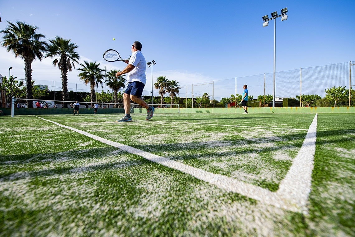 dos hombres están jugando al tenis en una cancha de tenis
