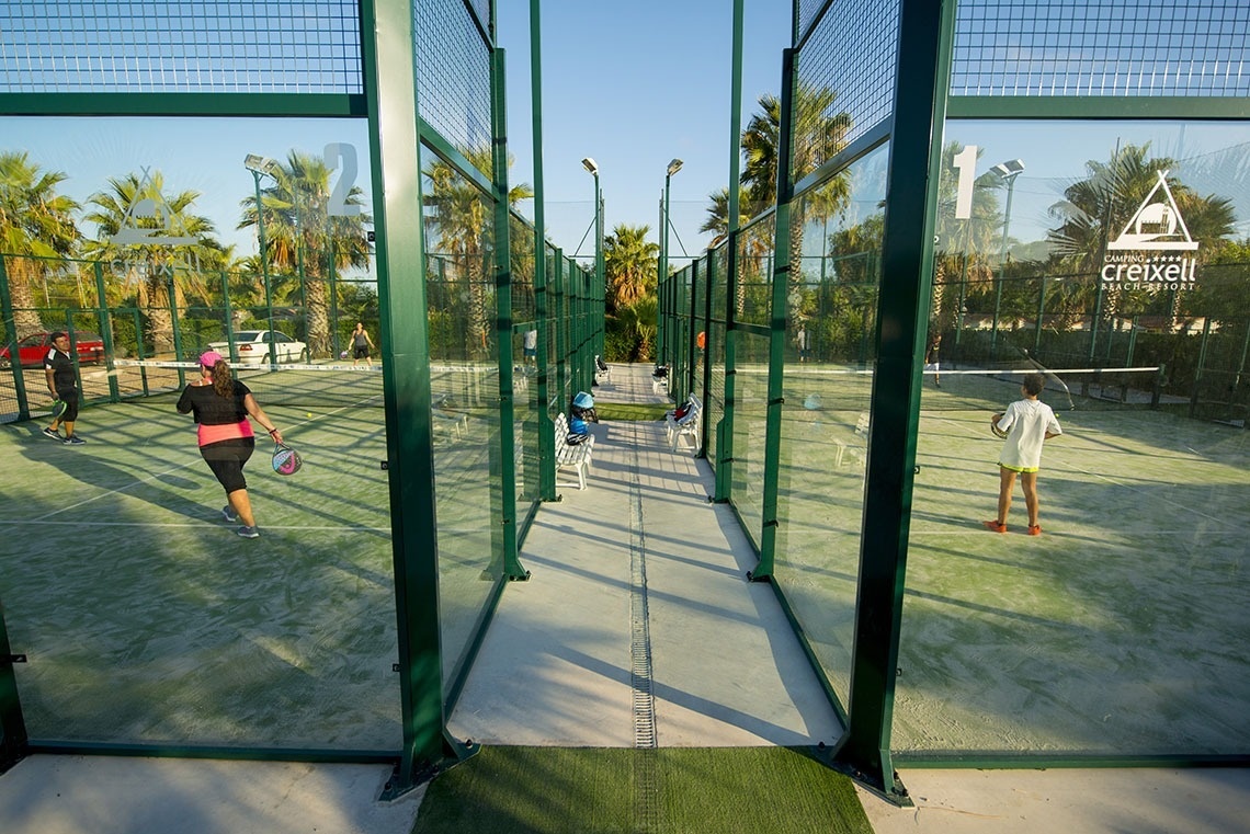 una mujer sostiene una raqueta de pádel en una cancha de pádel