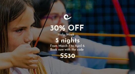 a family stands on the beach watching the sun set