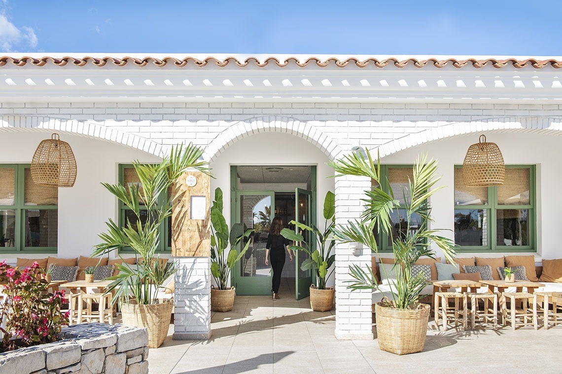 una mujer camina hacia la puerta de una casa blanca