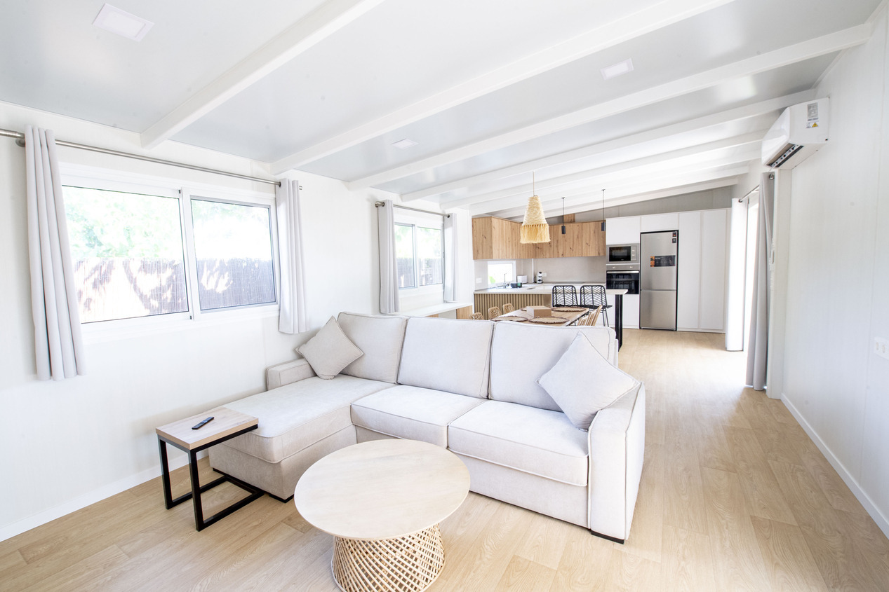 Séjour lumineux avec canapé confortable et cuisine moderne. Idéal pour vos Creixell camping & family resort.