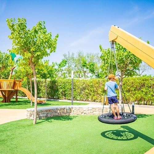 un niño juega en un columpio de neumáticos en un parque