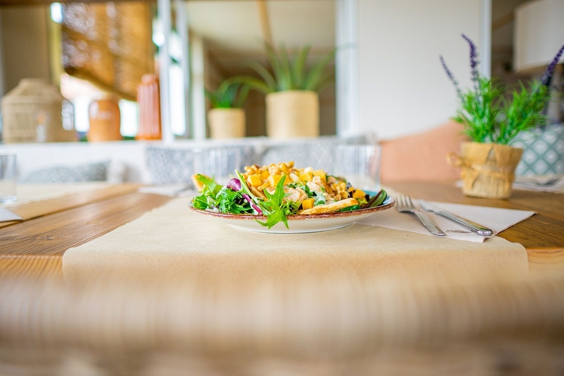 un plato de ensalada está sobre una mesa de madera