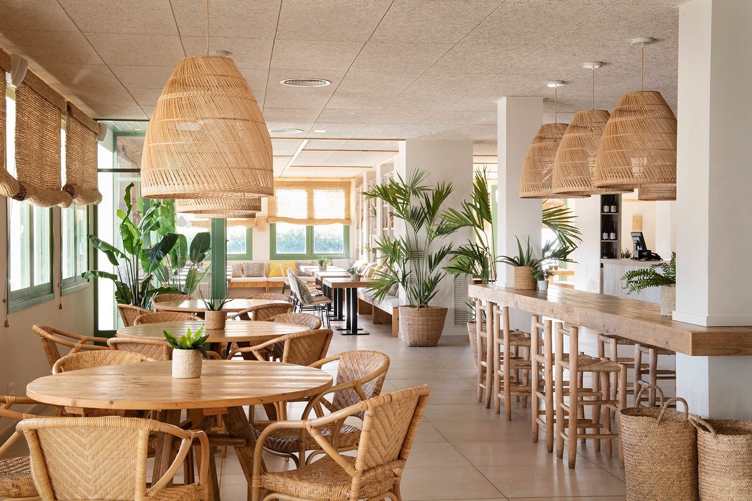 un restaurante lleno de mesas y sillas de mimbre