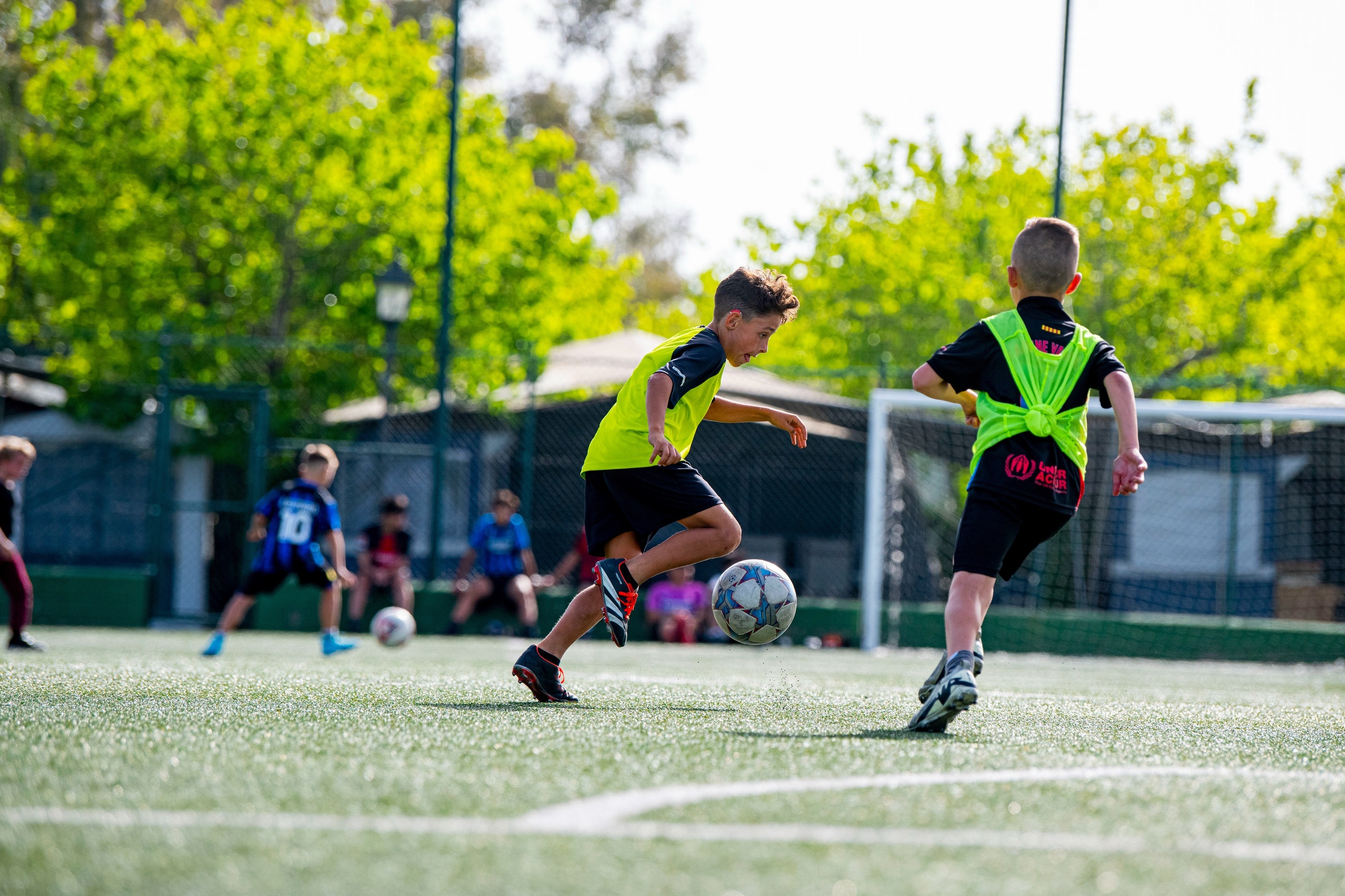 dos niños juegan al fútbol en un campo y uno de ellos lleva una camiseta con el número 10