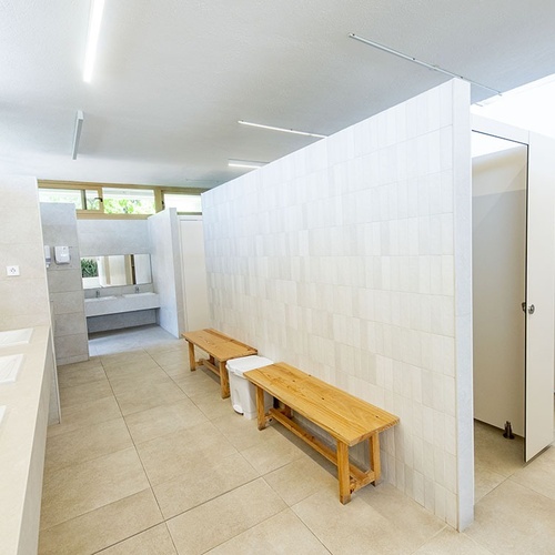 un baño con lavabos y bancos de madera