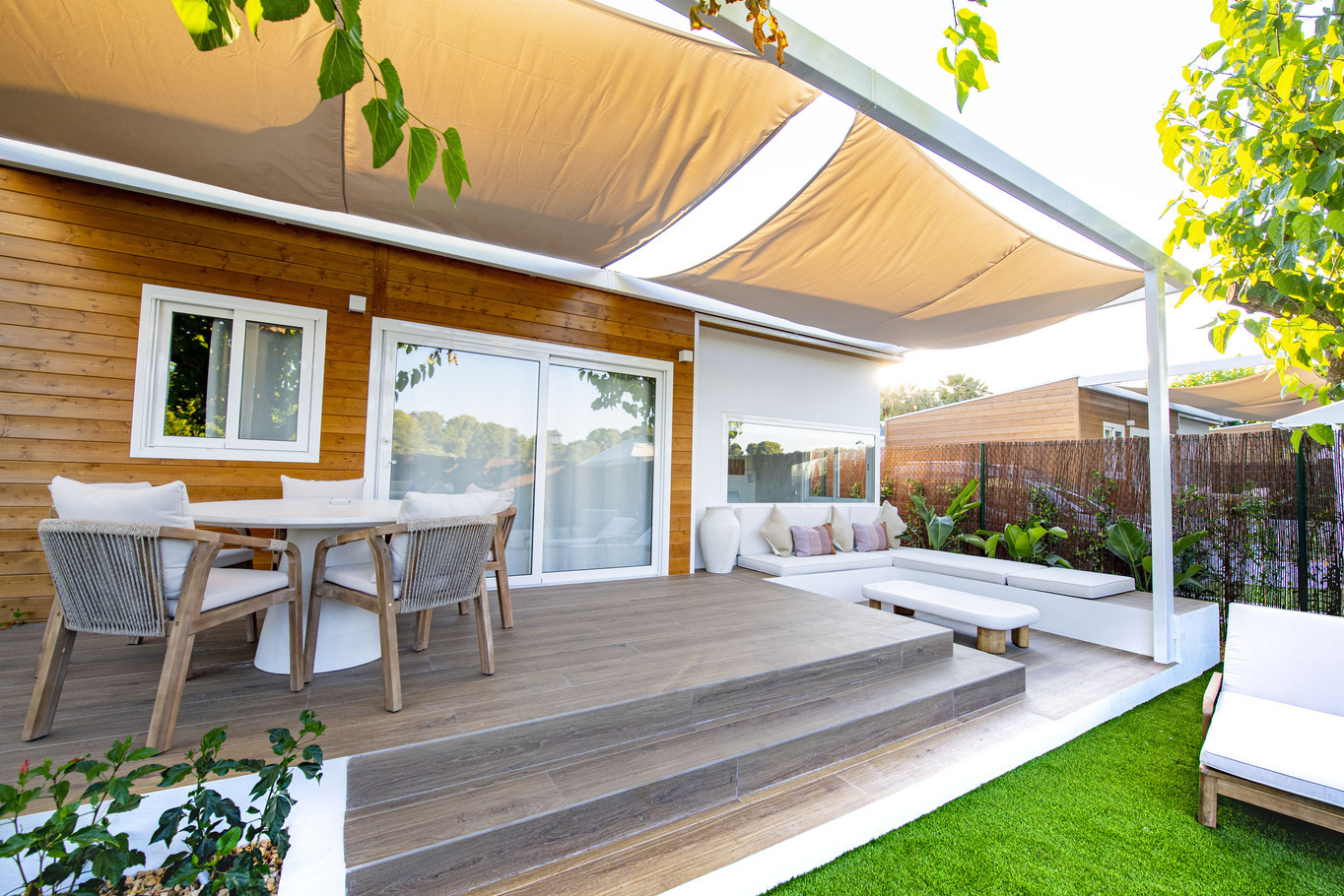 Terrasse moderne avec salon extérieur, chaises et table pour votre séjour Creixell camping & family resort.