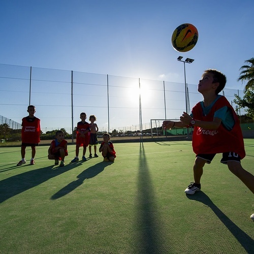 un grupo de niños están jugando al baloncesto en una cancha