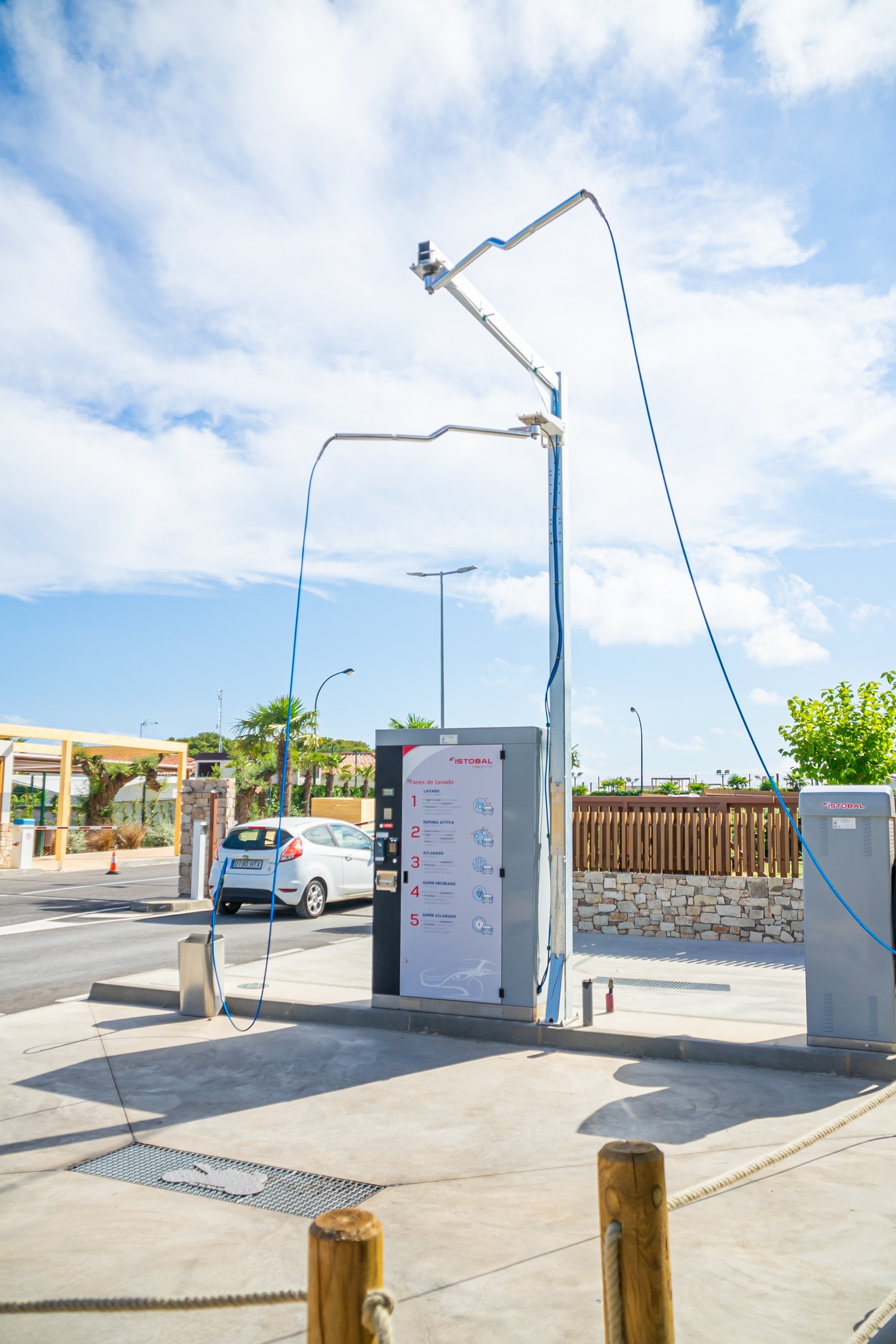 una mujer lava un coche con una manguera de alta presión
