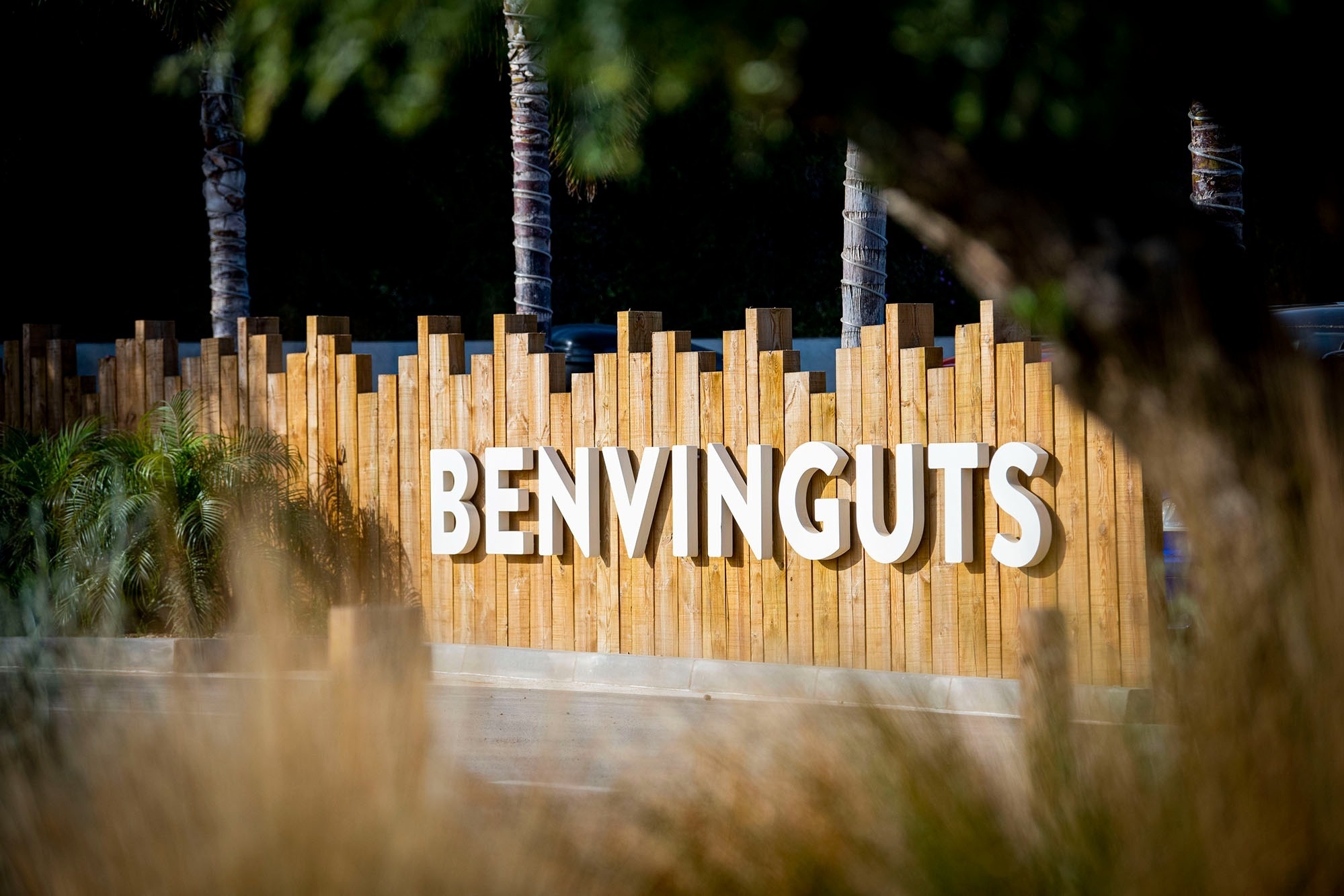 un letrero de madera con la palabra benvinguts en letras blancas