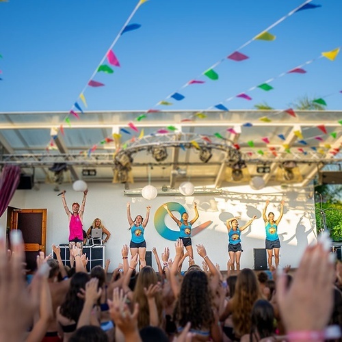 un grupo de mujeres están actuando en un escenario con un logotipo c en el fondo