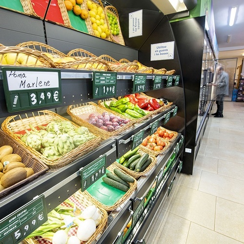 un puesto de frutas y verduras en un supermercado