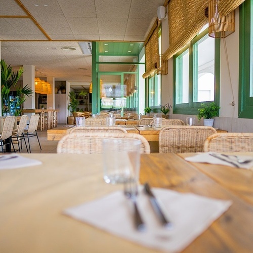 un restaurante vacío con mesas y sillas de mimbre