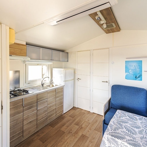 una cocina con una nevera y un sofá azul