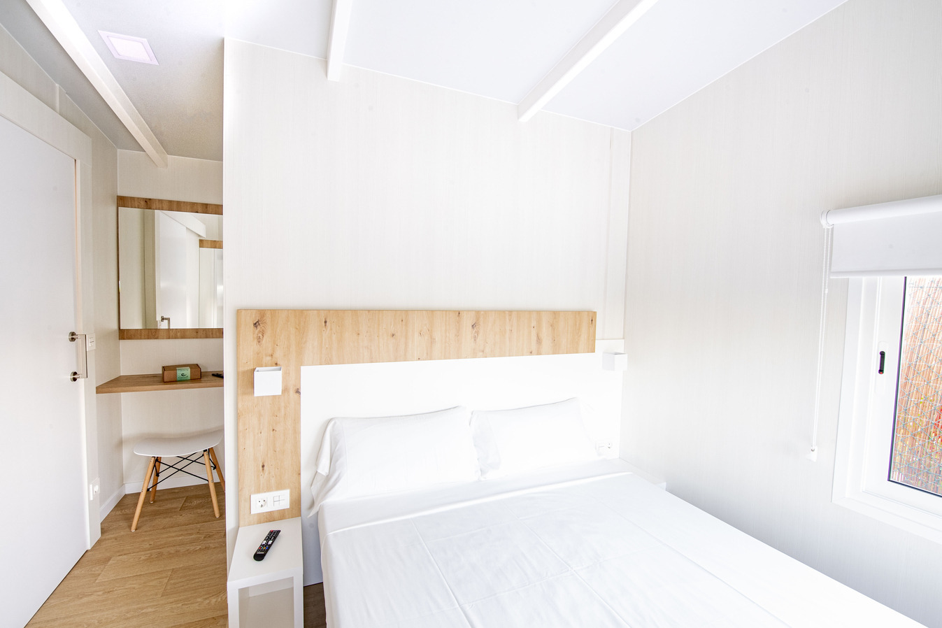 Chambre d'hôtel moderne avec lit double, coiffeuse et fenêtre, idéale pour votre séjour. Creixell camping & family resort