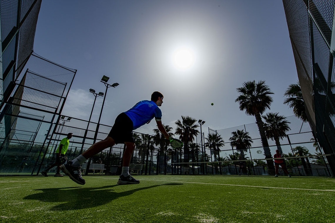 un hombre con una camisa azul y la palabra padel en la espalda
