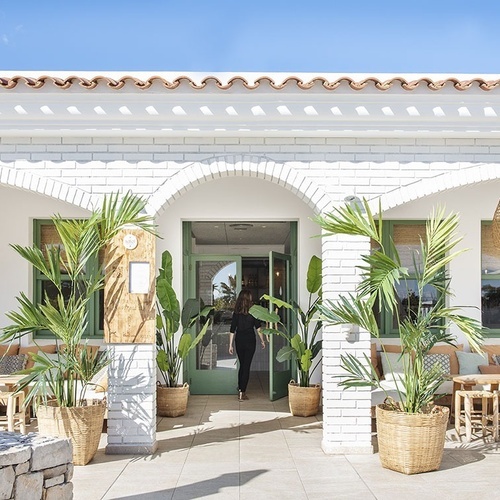 una mujer camina hacia la puerta de una casa blanca