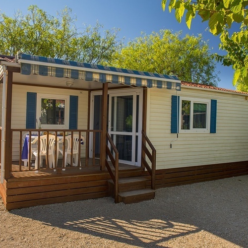una casa móvil con una mesa y sillas en el porche