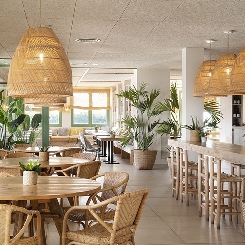 un restaurante con muchas mesas y sillas de mimbre