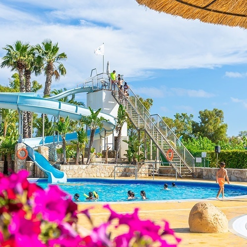 niños nadando en una piscina con un tobogán en el fondo