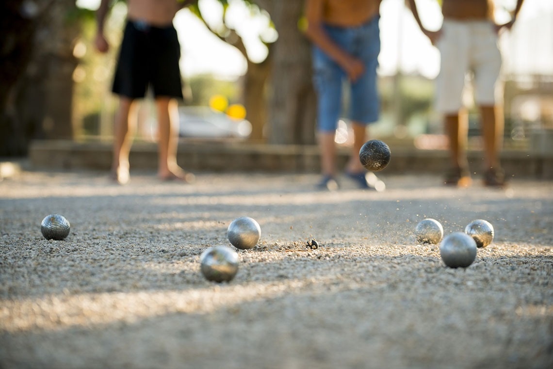 un grupo de niños están jugando a la petanca